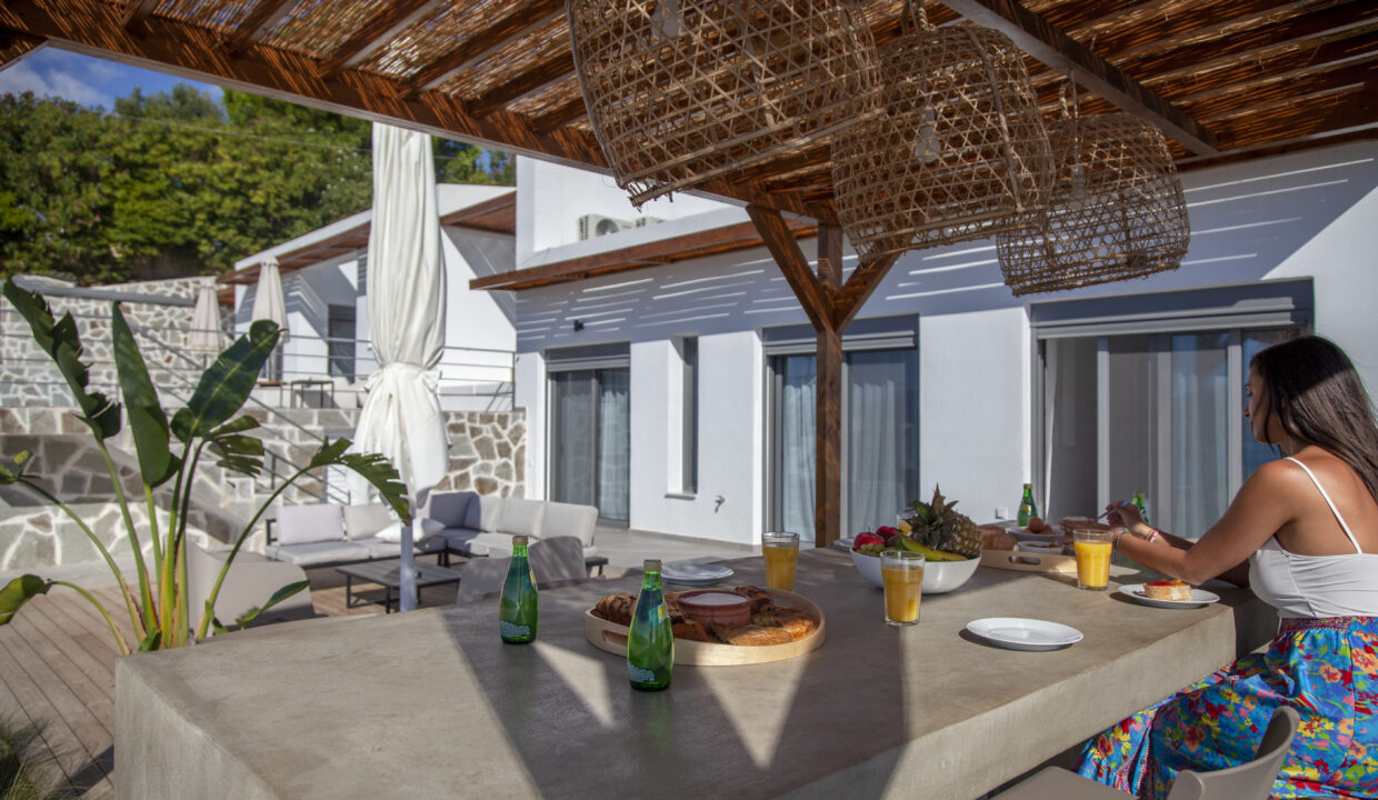 villa-empeiria-paleros-greece-girl-having-breakfast-at-outside-dining-area-with-view-on-the-house