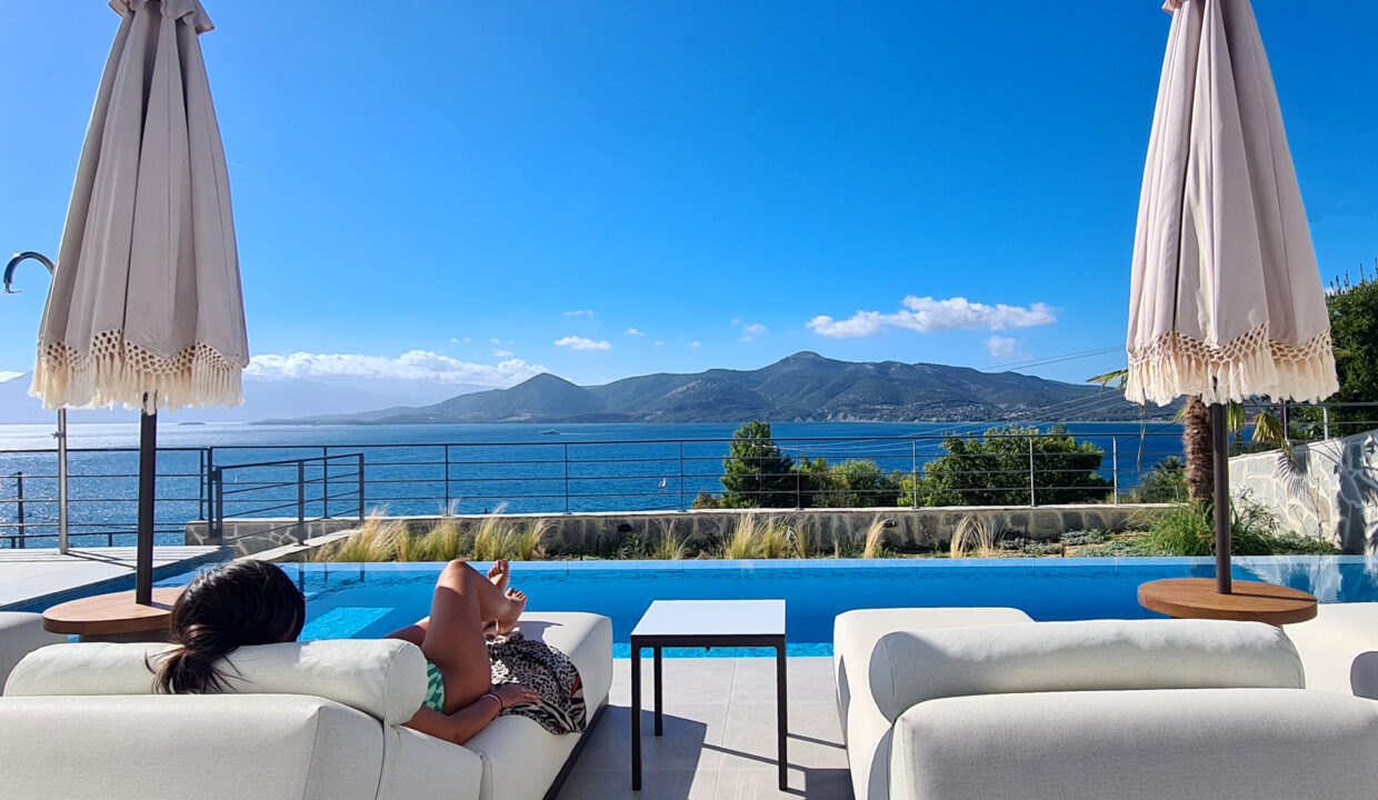 villa-empeiria-paleros-greece-girl-laying-on-sunbed-next-to-swimmingpool-with-view