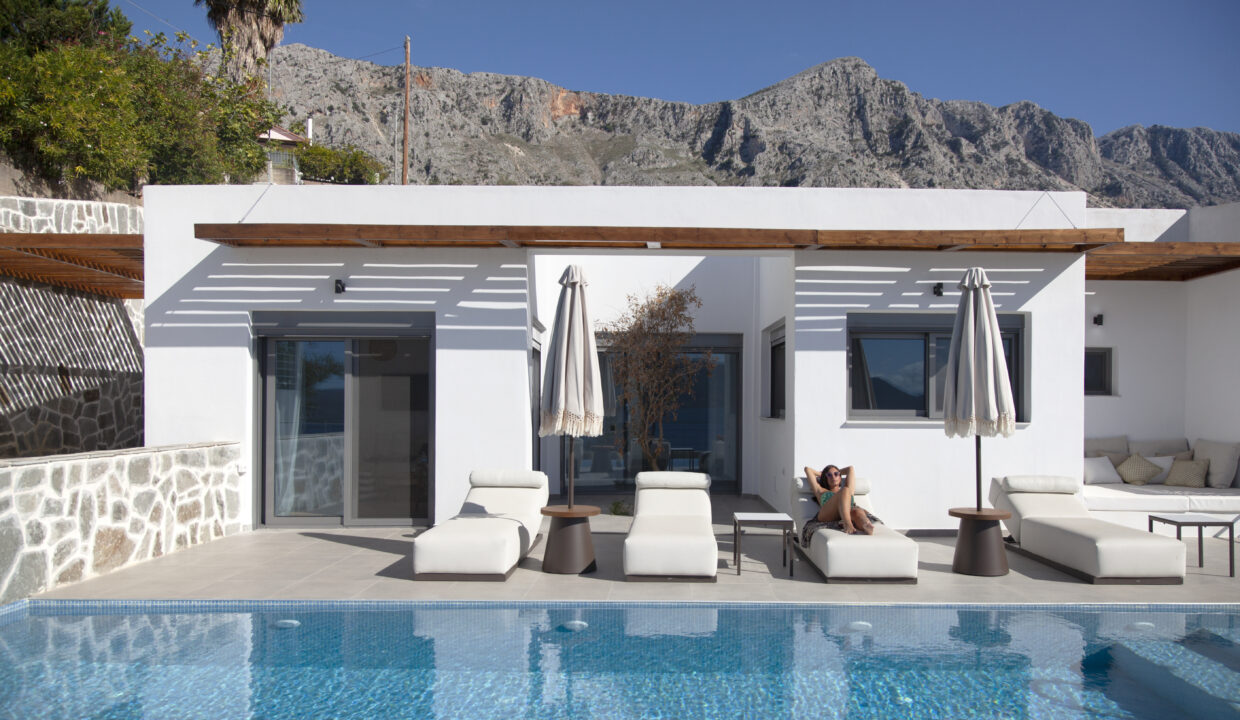 villa-empeiria-paleros-greece-girl-laying-on-sunbed-next-to-swimmingpool-with-view-on-the-mountains